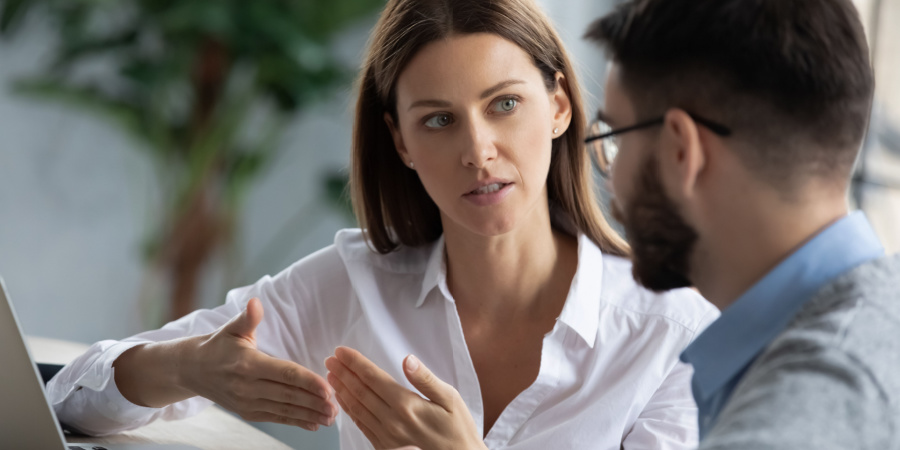 businesswoman talking with a young man | onboarding new hire training